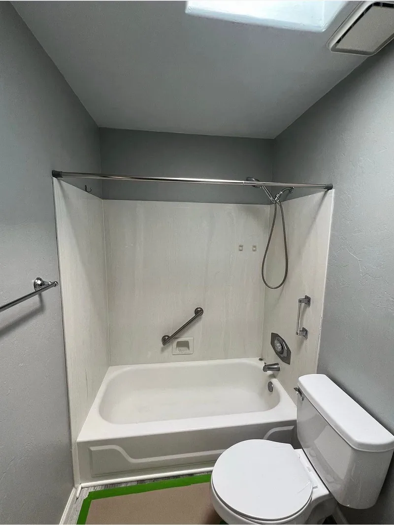 Bathroom update with a tub-and-shower surround and grab bars